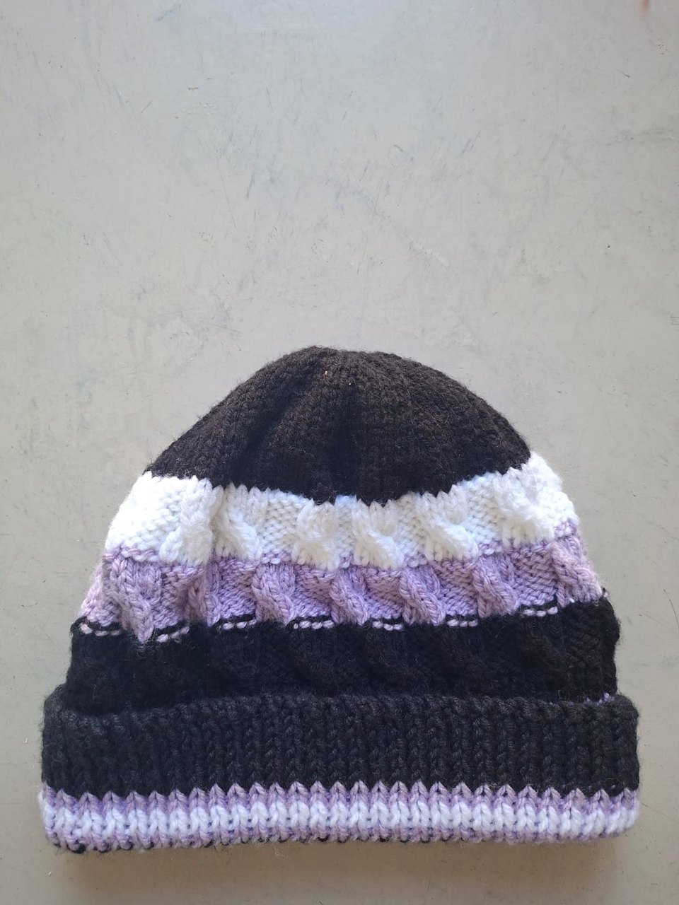Charcoal beanie with cream and lilac cable bands, hand-knitted at Kranshoek