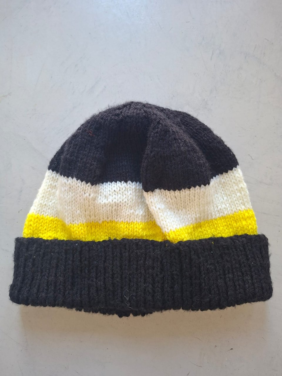 Charcoal beanie with cream and yellow bands, hand-knitted at Kranshoek