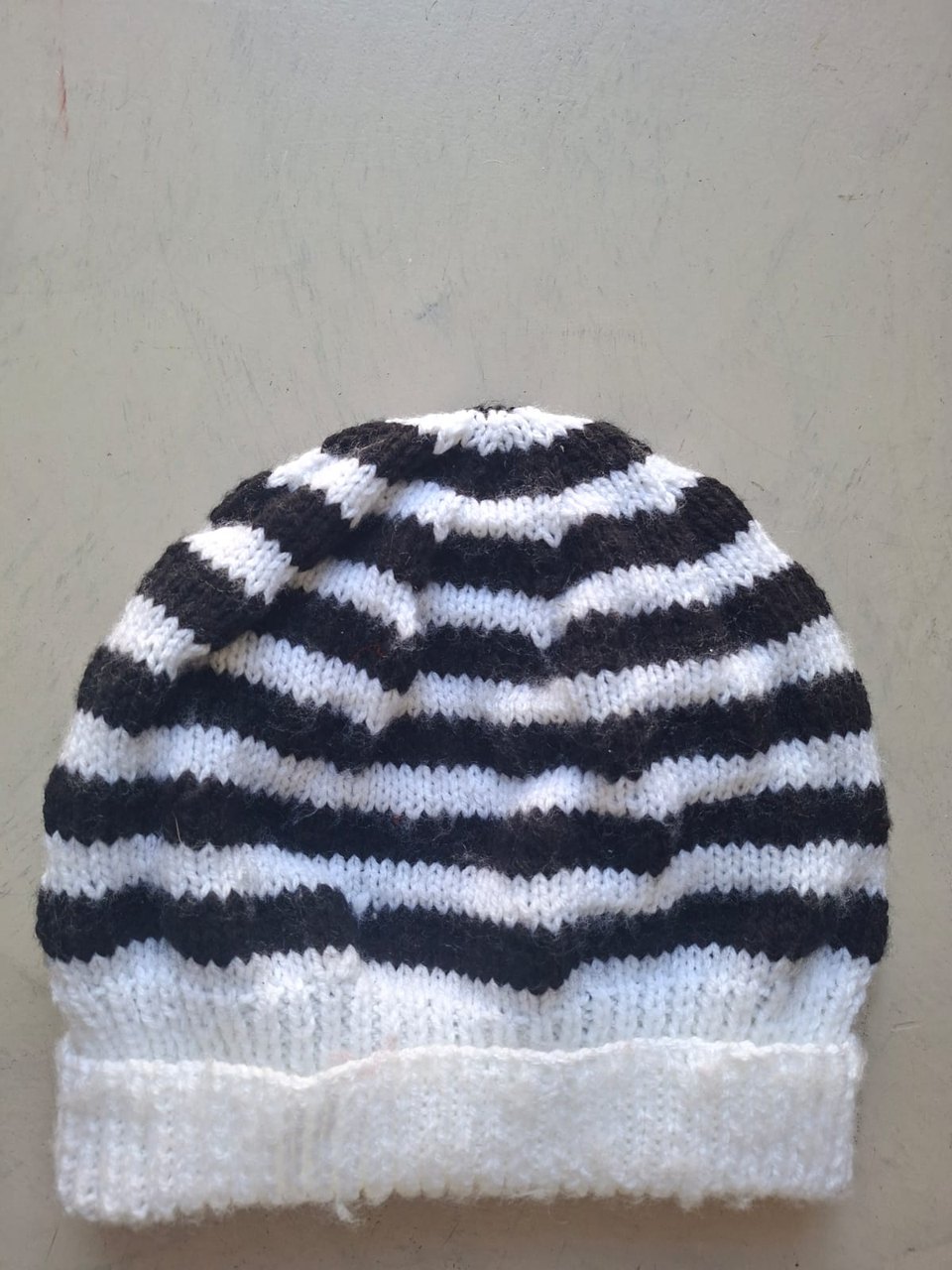 Black and white striped beanie with a white cuff, hand-knitted at Kranshoek