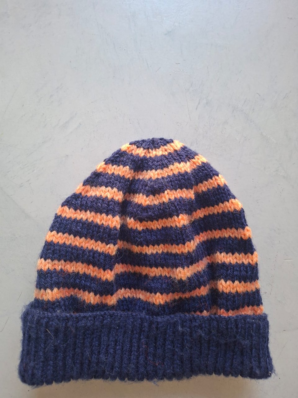 Navy beanie with orange stripes, hand-knitted at Kranshoek