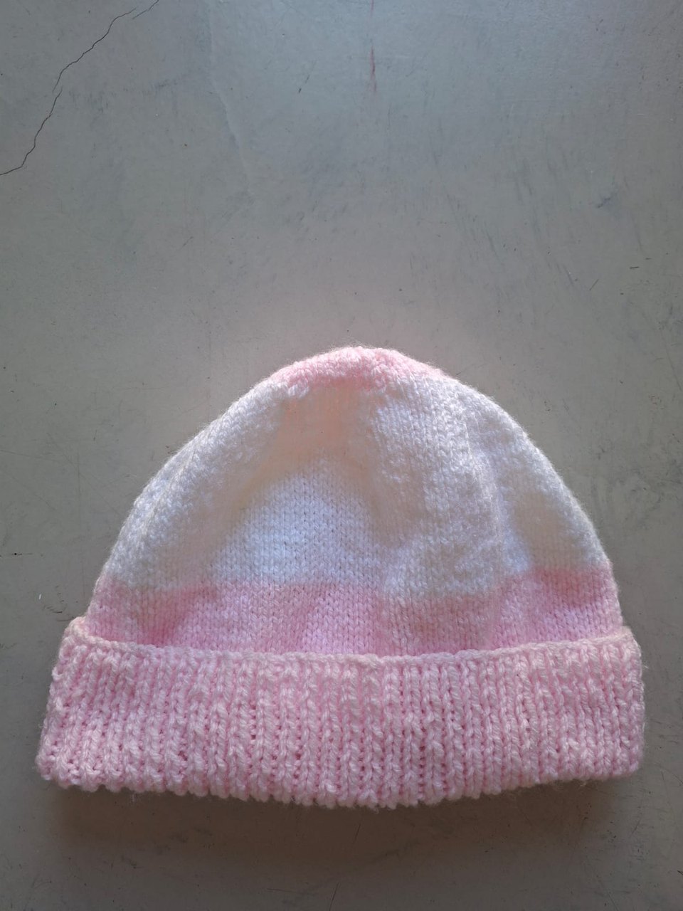 Pink beanie fading to white with a pink cuff, hand-knitted at Kranshoek