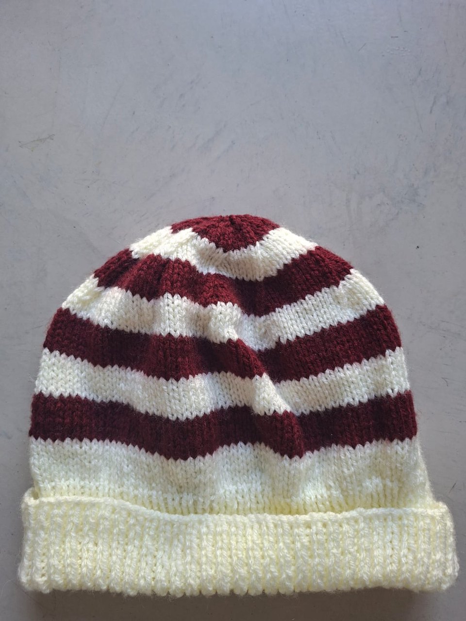 Burgundy and cream striped beanie, hand-knitted at Kranshoek
