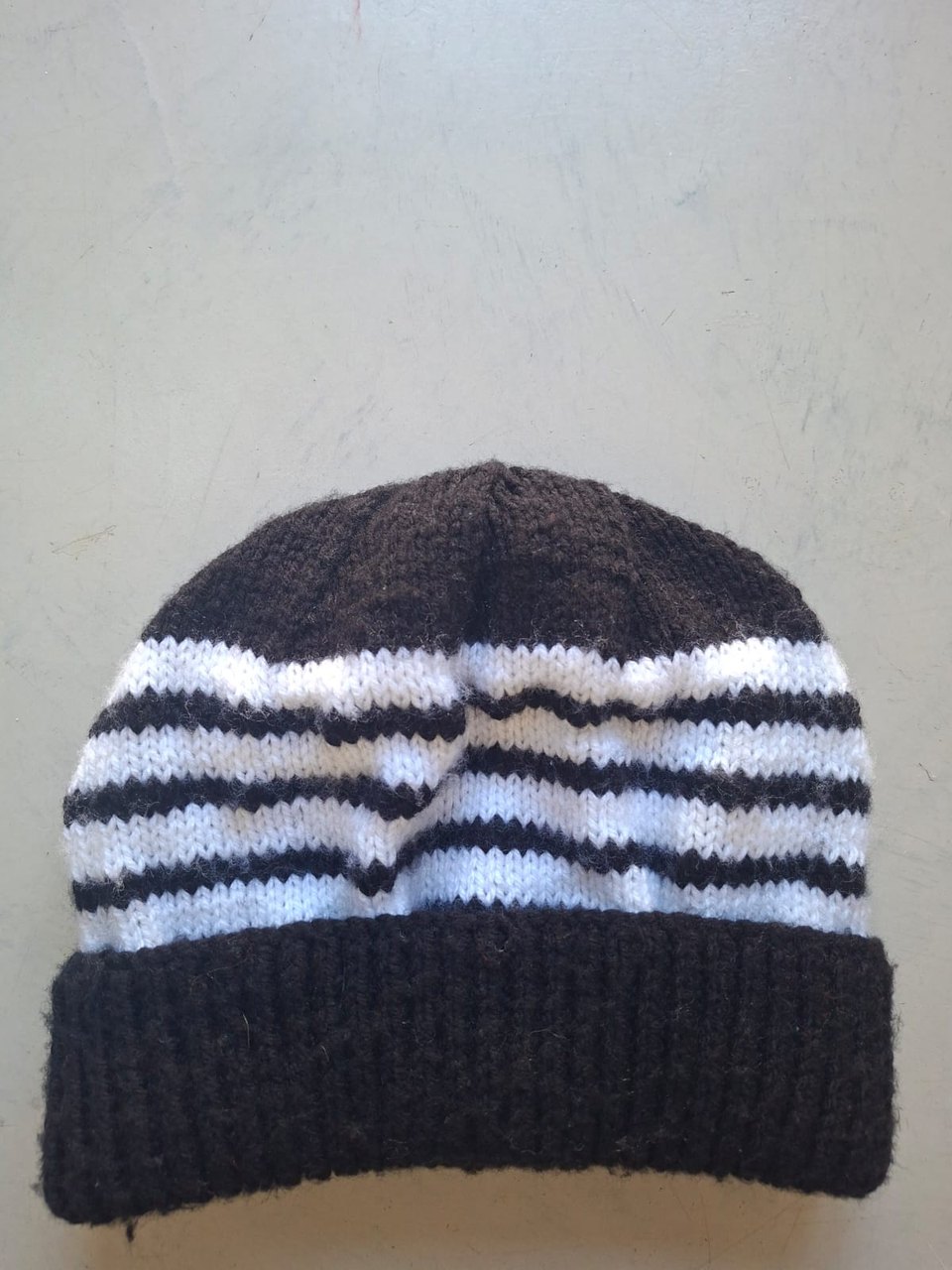 Dark brown beanie with white stripes, hand-knitted at Kranshoek