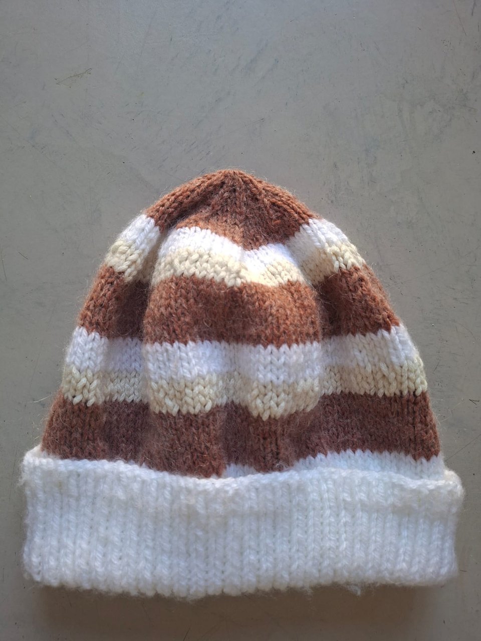 Brown, tan and cream striped beanie with a white cuff, hand-knitted at Kranshoek